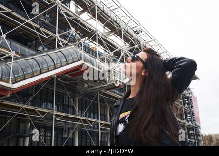 Une fille dans une veste en cuir et des lunettes devant le Centre Pompidou de Paris Banque D'Images