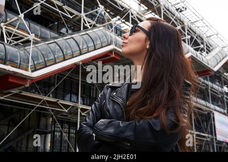 Une fille dans une veste en cuir et des lunettes devant le Centre Pompidou de Paris Banque D'Images