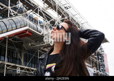 Une fille dans une veste en cuir et des lunettes devant le Centre Pompidou de Paris Banque D'Images