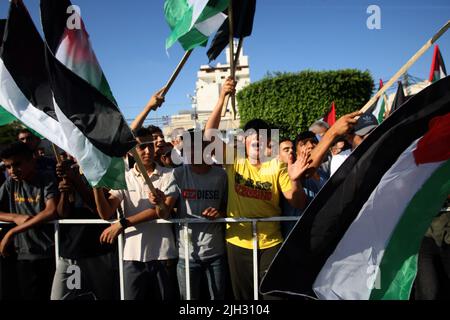 Gaza, Palestine. 14th juillet 2022. Les manifestants palestiniens scandent des slogans et brandent le drapeau national alors qu'ils se rassemblent pour protester contre la visite du président américain Joe Biden en Israël à Gaza jeudi, 14 juillet 2022. Crédit : UPI/Alay Live News Banque D'Images