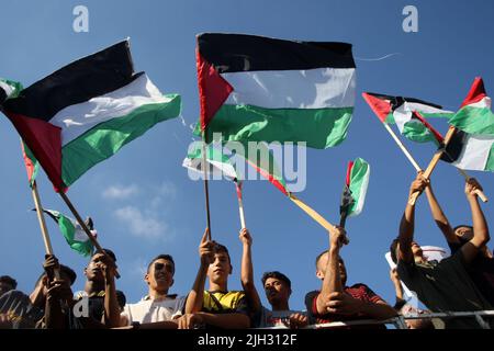 Gaza, Palestine. 14th juillet 2022. Les manifestants palestiniens scandent des slogans et brandent le drapeau national alors qu'ils se rassemblent pour protester contre la visite du président américain Joe Biden en Israël à Gaza jeudi, 14 juillet 2022. Crédit : UPI/Alay Live News Banque D'Images