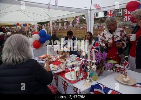 Les gens qui ont le thé de l'après-midi à Street Party célébrant la Reine Elizabeth II Platinum Jubilee Surrey Angleterre Banque D'Images