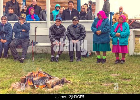 Des aînés Dénés et d'autres spectateurs lors d'une cérémonie d'alimentation en feu, dans la communauté autochtone du nord de Deline, dans les Territoires du Nord-Ouest, au Canada Banque D'Images