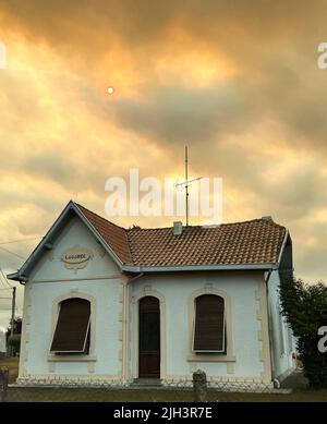 Sanguinet, France. 14th juillet 2022. De denses panaches de fumée provenant d'un feu de forêt obscurcissent le soleil sur la côte atlantique à environ 60 au sud-ouest de Bordeaux. En début de matinée, les forces d'urgence ont de nouveau évacué une colonie et amené environ 60 personnes en sécurité, puis elles ont également évacué une communauté d'environ 4000 personnes. Selon la préfecture, environ 1000 pompiers ont été déployés dans des incendies autour de Tteste-de-Buch et Landiras. Credit: Holger Mehlig/dpa/Alay Live News Banque D'Images