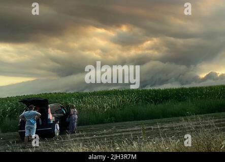 La teste de Buch, France. 14th juillet 2022. Les touristes se tiennent sur le côté de la route et regardent les nuages de fumée d'un feu de forêt sur la côte Atlantique environ 60 au sud-ouest de Bordeaux. Dans les premières heures du matin, les forces d'urgence ont de nouveau évacué une colonie et amené environ 60 personnes en sécurité, puis elles ont également évacué une communauté d'environ 4000 personnes. Selon la préfecture, environ 1000 pompiers ont été déployés dans des incendies autour de Tteste-de-Buch et Landiras. Credit: Holger Mehlig/dpa/Alay Live News Banque D'Images