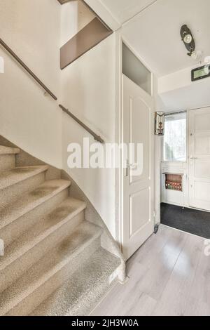 Depuis le dessus de l'escalier étroit en spirale avec des escaliers blancs et des balustrades sur le mur à l'intérieur de l'appartement moderne Banque D'Images