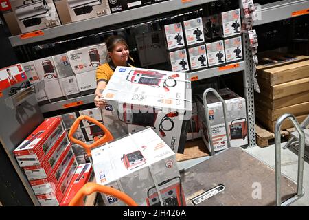 Bavière, Allemagne. 14th juillet 2022. 14 juillet 2022, Bavière, München Fröttmaning: Jessica Bendorf, une employée de Hornbach, déplace un radiateur de ventilateur d'une étagère sur un chariot à Hornbach Baumarkt Fröttmaning. La crainte de pénuries de gaz au cours de l'hiver à venir provoque une augmentation de la demande de radiateurs à ventilateur, de radiateurs à convecteurs et de radiateurs à huile au milieu de l'été. Photo: Felix Hörhager/dpa crédit: dpa Picture Alliance/Alay Live News Banque D'Images