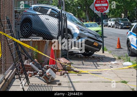 New York, États-Unis. 14th juillet 2022. Les policiers du département de police de New York (NYPD) ont relevé les dommages après qu'une voiture a été hors de contrôle et qu'elle s'est écraée dans une maison du quartier d'Astoria à New York. Le conducteur a perdu le contrôle de sa voiture, vers 7 le matin, en faisant un demi-tour et un accident à travers une clôture de maison et un patio. Le conducteur n'a pas été blessé dans l'accident. Crédit : SOPA Images Limited/Alamy Live News Banque D'Images