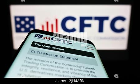 Téléphone mobile avec le site Web de la US Commodity futures Trading Commission (CFTC) à l'écran devant le logo. Faites la mise au point dans le coin supérieur gauche de l'écran du téléphone. Banque D'Images