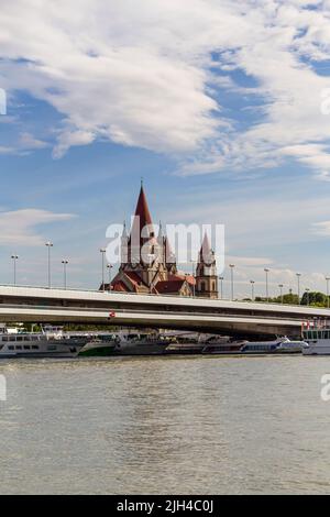 VIENNE, AUTRICHE - 17 août 2019 : Eglise Saint François d'Assise, pont impérial et Danube avec bateaux de croisière au port de Vienne, Autriche Banque D'Images