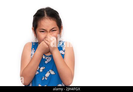 Mignon enfant asiatique fille ferme son nez avec deux mains, un enfant malheureux se sentant mal de l'odeur, isolé portrait enfant fille sur blanc backgroun Banque D'Images