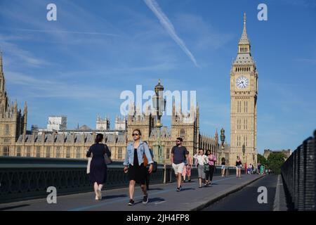 Les gens traversent le pont de Westminster à Londres. Date de la photo: Vendredi 15 juillet 2022. Banque D'Images