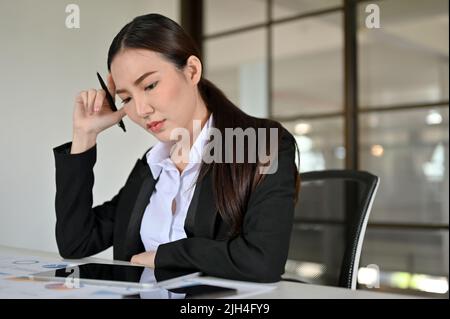 Une jeune femme d'affaires ou un travailleur d'affaires asiatique professionnel s'est concentrée sur sa tâche au bureau. Banque D'Images