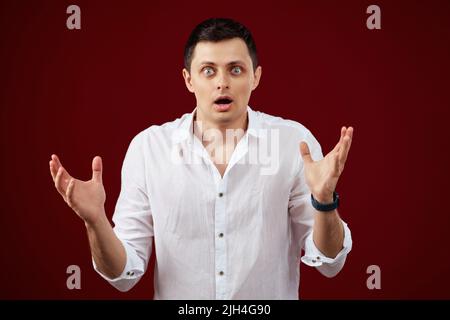 surprise brunette choqué homme en chemise blanche Banque D'Images