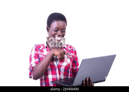 belle jeune femme heureuse, avec écouteurs dans son oreille, pointant le doigt vers l'écran de l'ordinateur portable tout en ayant un appel vidéo. Banque D'Images