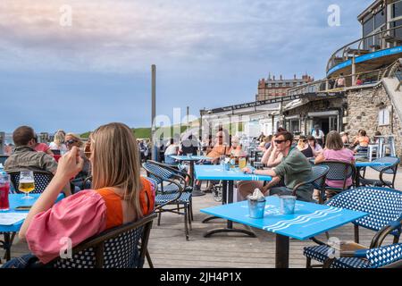 Vacanciers se détendant sur la terrasse extérieure du Fistral Beach Bar à Fistral à Newquay, en Cornouailles, au Royaume-Uni. Banque D'Images