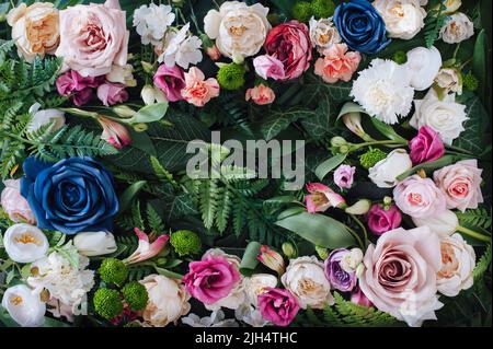 Composition créative avec fleurs de printemps colorées et feuilles vertes. Carte de vœux ou arrière-plan fleuri avec espace pour le texte. Banque D'Images