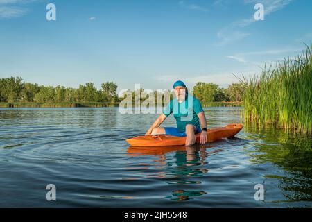 Athlétique, homme âgé pagayer un kayak sur un lac du Colorado, ce sport nautique combine les aspects du kayak et de la natation Banque D'Images