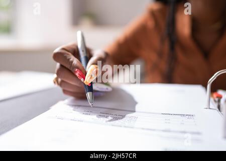 Image rognée d'une femme d'affaires calculant la facture au bureau Banque D'Images