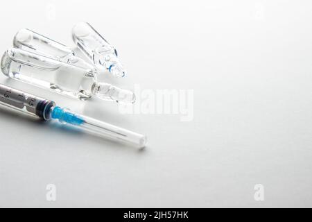 Flacons et seringue sur table lumineuse. Vaccination et immunisation Banque D'Images