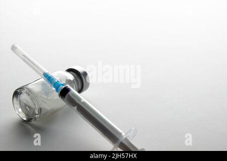 Flacons et seringue sur table lumineuse. Vaccination et immunisation Banque D'Images
