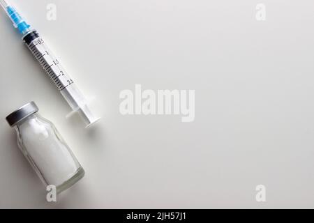 Flacons et seringue sur table lumineuse. Vaccination et immunisation Banque D'Images