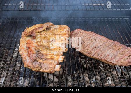 Il n'y a rien de plus américain que des steaks de bœuf grillés et des côtes de porc sur un barbecue chaud Banque D'Images
