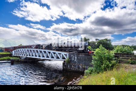 FORT WILLIAM SCOTLAND TRAIN À VAPEUR JACOBITE TRAVERSANT LE PONT SUSPENDU EN MÉTAL DE LA BANAVIE AVEC BEN NEVIS EN ARRIÈRE-PLAN Banque D'Images