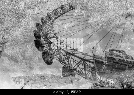 Image en noir et blanc du London Eye reflétée dans une flaque Banque D'Images