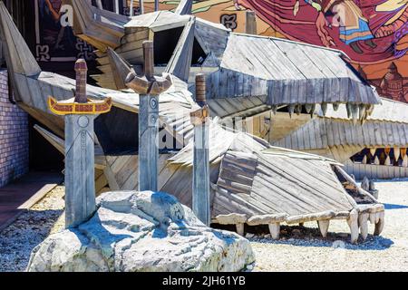 Russie, Sotchi 14.05.2022. Trois épées fabuleuses sur fond de crânes en bois de dragons. Folklore de conte de fées. Décor de parc d'attractions Banque D'Images