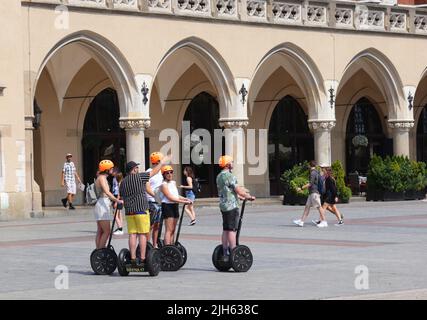 Cracovie. Cracovie. Pologne. Groupe de touristes sur segway avec guide en face de Sukiennice Cloth Hall au milieu de la place du marché principal, au centre du t Banque D'Images