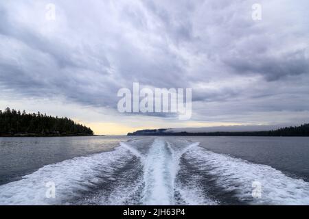 Un moteur hors-bord se réveille d'un bateau de croisière sur la mer dans un paysage marin avec l'horizon au-dessus de l'eau lors d'une journée nuageux à l'île de Langara située à Hai Banque D'Images
