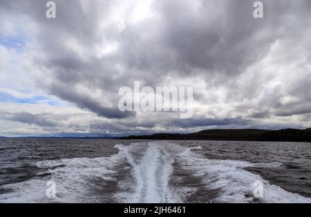 Un moteur hors-bord se réveille d'un bateau de croisière sur la mer dans un paysage marin avec l'horizon au-dessus de l'eau lors d'une journée nuageux à l'île de Langara située à Hai Banque D'Images