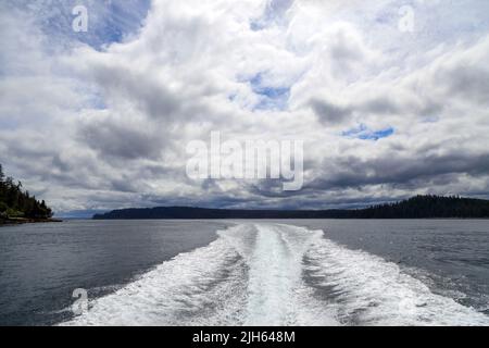 Un moteur hors-bord se réveille d'un bateau de croisière sur la mer dans un paysage marin avec l'horizon au-dessus de l'eau lors d'une journée nuageux à l'île de Langara située à Hai Banque D'Images