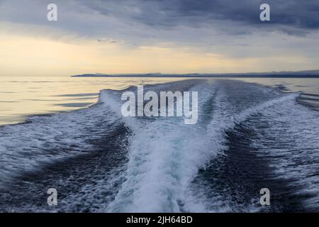 Un moteur hors-bord se réveille d'un bateau de croisière sur la mer dans un paysage marin avec l'horizon au-dessus de l'eau lors d'une journée nuageux à l'île de Langara située à Hai Banque D'Images