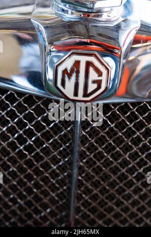 Gros plan de l'écusson MG chromé poli et de la calandre du radiateur sur une voiture de sport britannique classique Banque D'Images