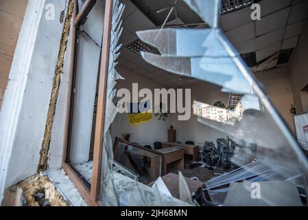 Vinnytsia, Ukraine. 15th juillet 2022. Un drapeau ukrainien est encore suspendu sur le mur à l'intérieur d'une fenêtre cassée de l'intérieur des bureaux du gouvernement qui ont été attaqués hier par les Russes dans la ville de Vinnytsia. (Credit image: © Hector Adolfo Quintanar Perez/ZUMA Press Wire) Credit: ZUMA Press, Inc./Alamy Live News Banque D'Images