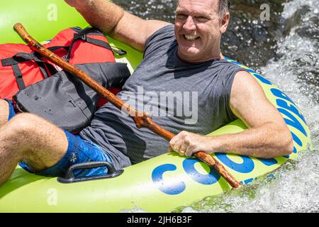 Papa souriant appréciant un jour de tubing sur la rivière Chattahoochee avec sa famille à Helen, en Géorgie. (ÉTATS-UNIS) Banque D'Images