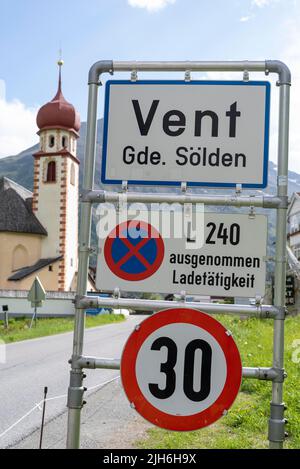 Vent dans les Alpes Oetztal, panneau d'entrée du village, derrière lui l'église paroissiale, vent, Tyrol, Autriche Banque D'Images