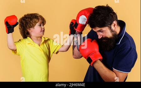 Formateur enseignant aux enfants comment frapper les poinçons. Formation de boxe pour enfants. Activité de l'enfance. Journée de remise en forme. Banque D'Images