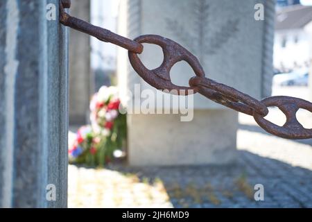 Des chaînes rouillées et anciennes reliées à un mur en béton pour une barrière et une enceinte à un quai. Gros plan d'une chaîne de rampe connectée au niveau d'un orifice utilisé pour l'arrêt Banque D'Images