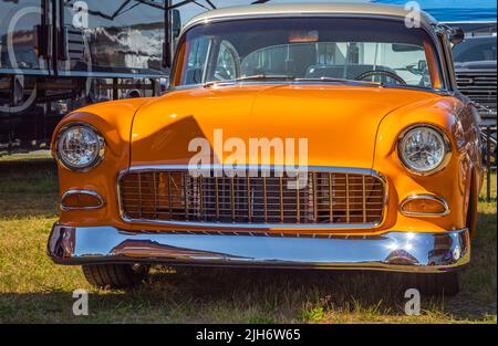 Voiture classique Orange american Chevrolet Bel air Cabriolet garée à l'extérieur par temps ensoleillé. Vue rapprochée d'une Chevrolet 1955 magnifiquement restaurée. Personne, t Banque D'Images