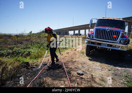 Richmond, États-Unis. 15th juillet 2022. Un pompier utilise de l'eau pour éteindre le feu de broussailles à Richmond. Les pompiers répondent à un incendie de brosse à Richmond, le feu de brosse a commencé vers 1 h 22 et a été contenu par 2 h. la cause de l'incendie est la combustion ouverte de déchets dans la région. (Photo de Michael Ho Wai Lee/SOPA Images/Sipa USA) crédit: SIPA USA/Alay Live News Banque D'Images