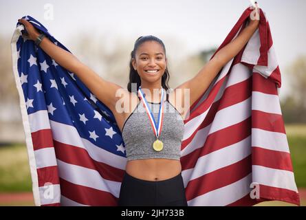 Levez votre drapeau. Portrait court d'une jeune athlète féminine attrayante célébrant une victoire pour son pays. Banque D'Images