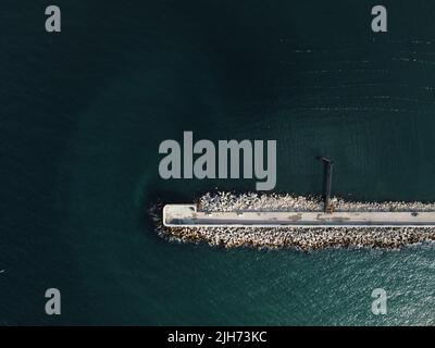 Vue aérienne d'un brise-lames par drone. Jetée de tétrapodes le long de la rive, vagues de mer se brisant sur la jetée de tétrapodes vue de drone Breakwater dans la mer, une collection Banque D'Images