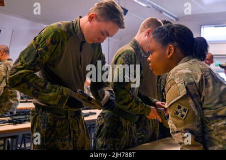 5 juillet 2022 - Huovinrinne, Finlande - Un soldat finlandais affecté à la Compagnie d'infanterie 1st, de l'unité de préparation du Bataillon Jaeger de Satakunta, pratique avec un pistolet M17 sous la supervision de soldats américains affectés à l'équipe de combat de la Brigade blindée 3rd, 4th Division d'infanterie pendant une académie de chef d'équipe à Huovinrinne, Finlande, 5 juillet 2022. L'équipe de combat de la Brigade blindée de 3rd, division d'infanterie de 4th, est parmi les autres unités affectées à la Division d'infanterie de 1st, travaillant fièrement aux côtés des alliés de l'OTAN et des partenaires de sécurité régionaux pour fournir des forces crédibles au corps V, le FO de l'Amérique Banque D'Images