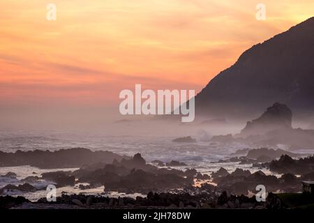 Coucher de soleil sur la côte rocheuse Tsitsikamma du parc national Garden route, Afrique du Sud. Banque D'Images