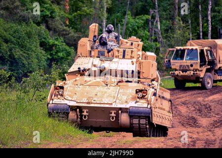 Drawsko Pomorskie, Pologne. 10th juin 2022. Des soldats américains avec 4th escadrons, 10th Cavalry Regiment, 3rd Armored Brigade combat Team, 4th Infantry Division mettent en scène un véhicule de combat M2A3 Bradley pour commencer l'entraînement de décontamination chimique, biologique, radiologique et nucléaire avec des soldats du 4th Chemical Regiment de l'armée polonaise à Drawsko Pomorskie, Pologne, 10 juin, 2022. L'ABCT 3/4th est parmi les autres unités affectées au V corps, le corps de déploiement avancé de l'Amérique en Europe qui travaille aux côtés des alliés de l'OTAN et des partenaires de sécurité régionaux pour fournir un forc digne de foi au combat Banque D'Images