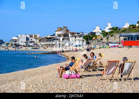 Lyme Regis, Dorset, Royaume-Uni. 16th juillet 2022. Météo au Royaume-Uni : les vacanciers et les habitants s'imprégnent du soleil matinal à la station balnéaire de Lyme Regis. Les gens appréciaient déjà la chaleur en 8am car beaucoup sont arrivés tôt pour trouver un endroit sur la plage. Credit: Celia McMahon/Alamy Live News Banque D'Images