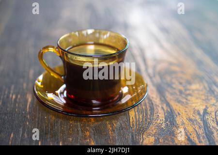 Une tasse de café de Java noir indonésien sur une table en bois avec un arrière-plan lumineux Banque D'Images